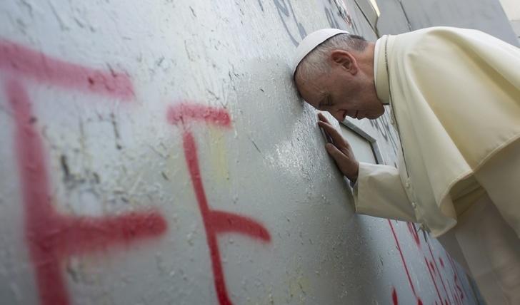 El papa Francisco reza ante el muro de separación entre Israel y Cisjordania