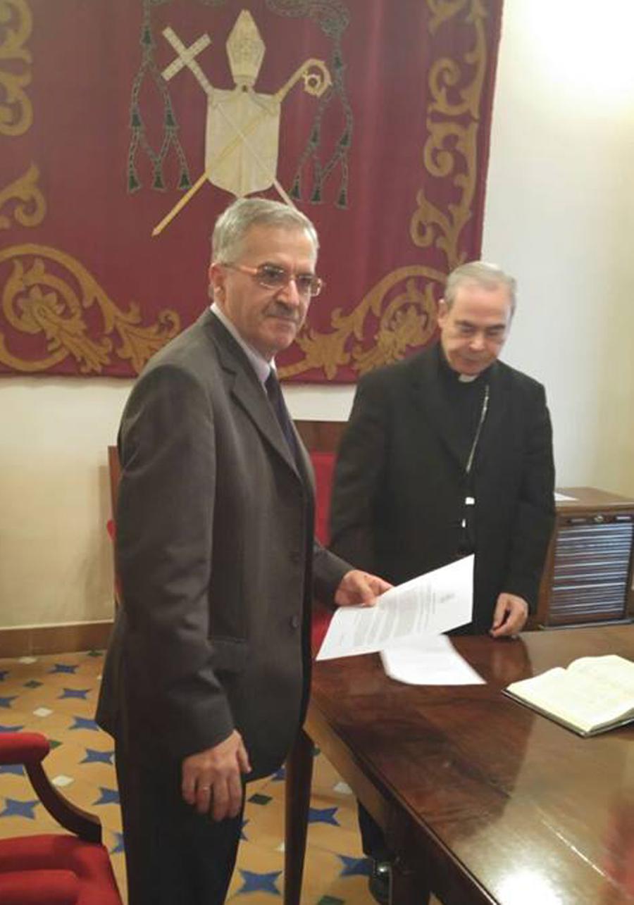 Andrés Serrano en el momento de la firma, ante el Obispo de Málaga