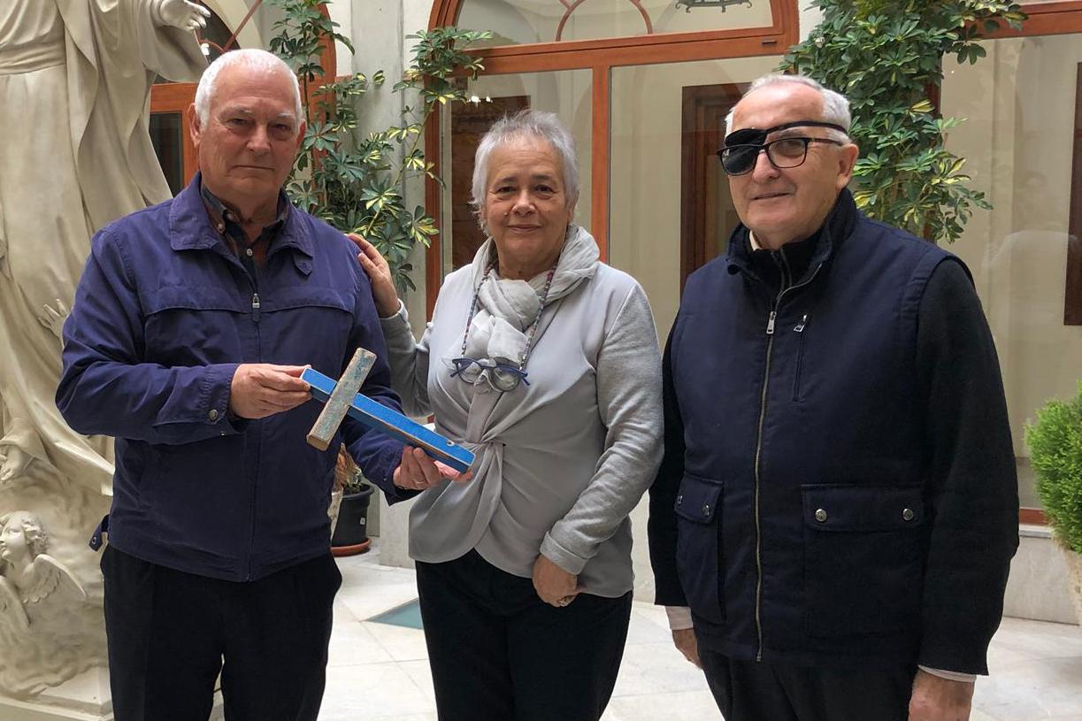 Ramón Muñoz, delegado diocesano de Migraciones, recibe de la embajadora de la Fundación, Graziella Cuccu, una réplica de la cruz hecha con tablas de barcas de migrantes naufragados, en compañía de Gabriel Leal, vicario de la Acción Sociocaritativa