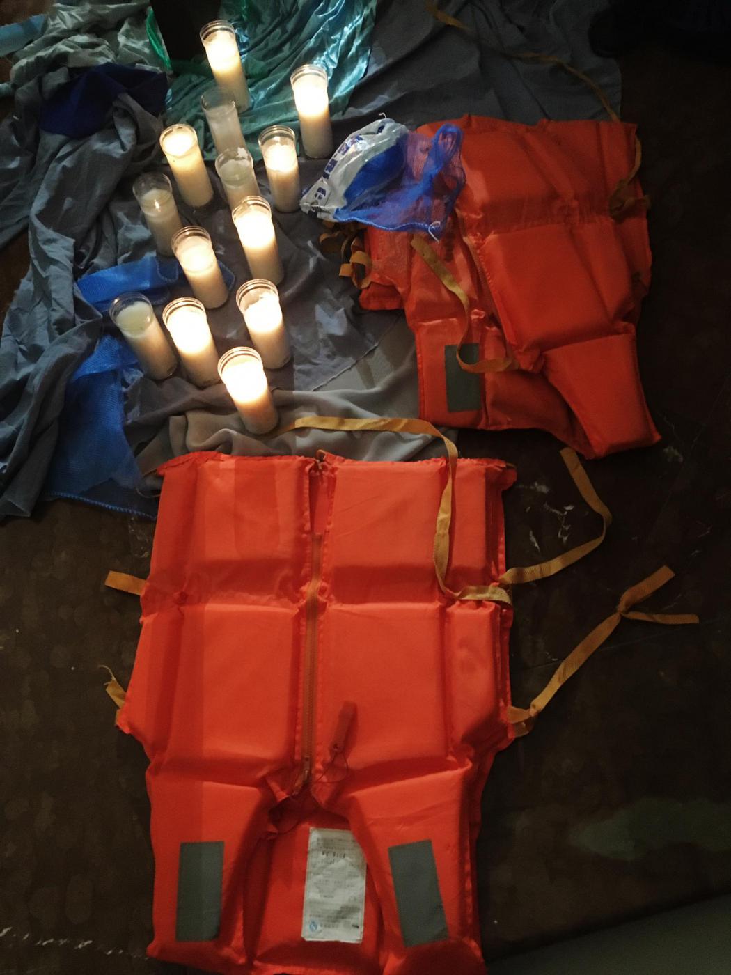 Salvavidas y velas a los pies de la cruz, en la parroquia del Carmen, en El Perchel // V. FLORES