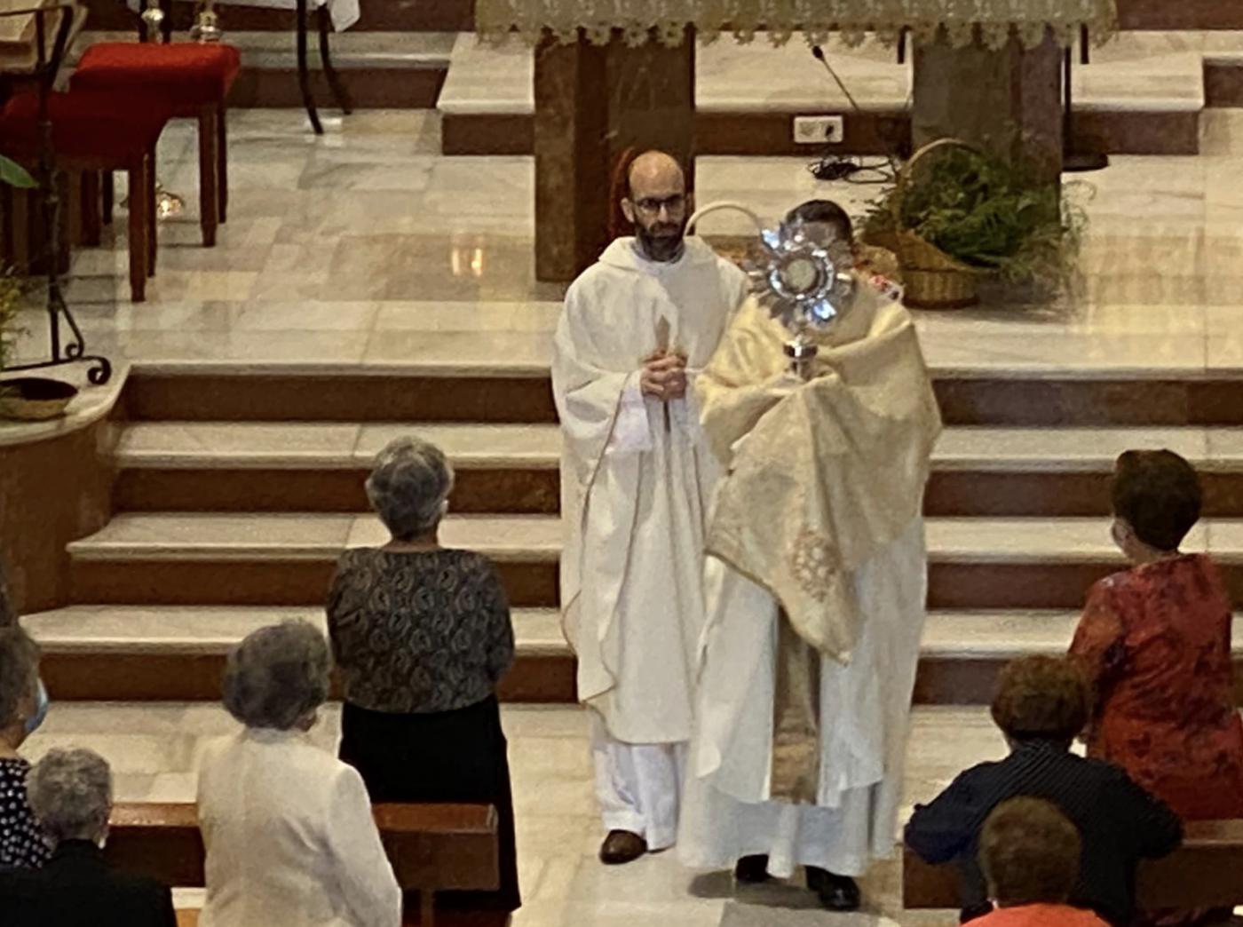El vicario general José Antonio Sánchez, porta la custodia junto al párroco, José Manuel Bacallado, durante la celebración del Corpus Christi en Yunquera