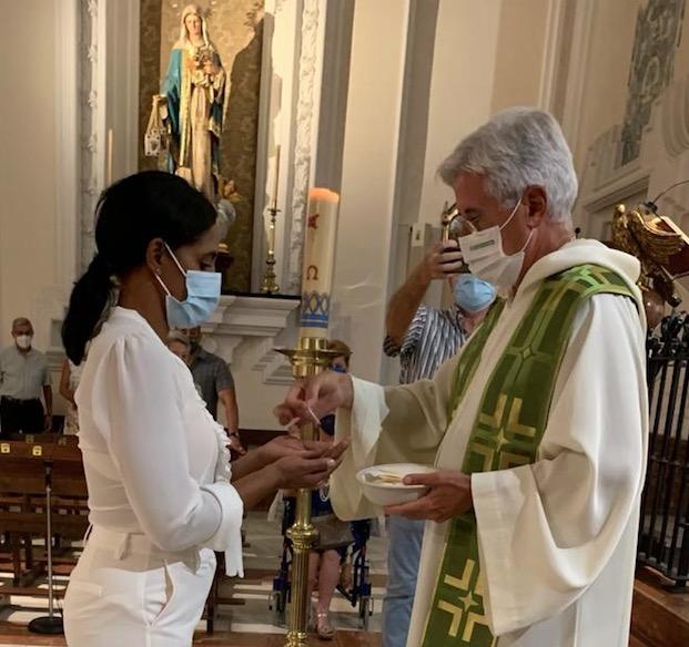 Yuriamna Alonso recibe el sacramento de la comunión, en la parroquia de Nuestra Señora del Carmen, en Málaga