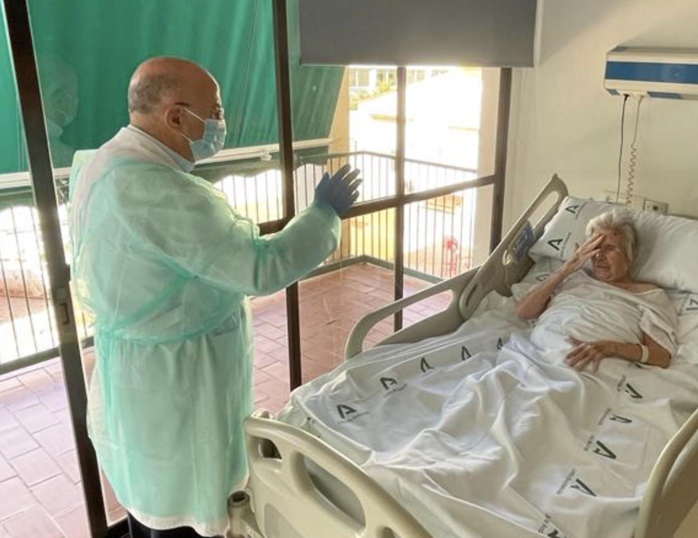 El consiliario de Pastoral de la Salud en Málaga, Carlos Acosta, visita a una mujer enferma en el hospital